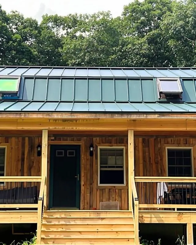 Cabin porch under a green standing seam roof