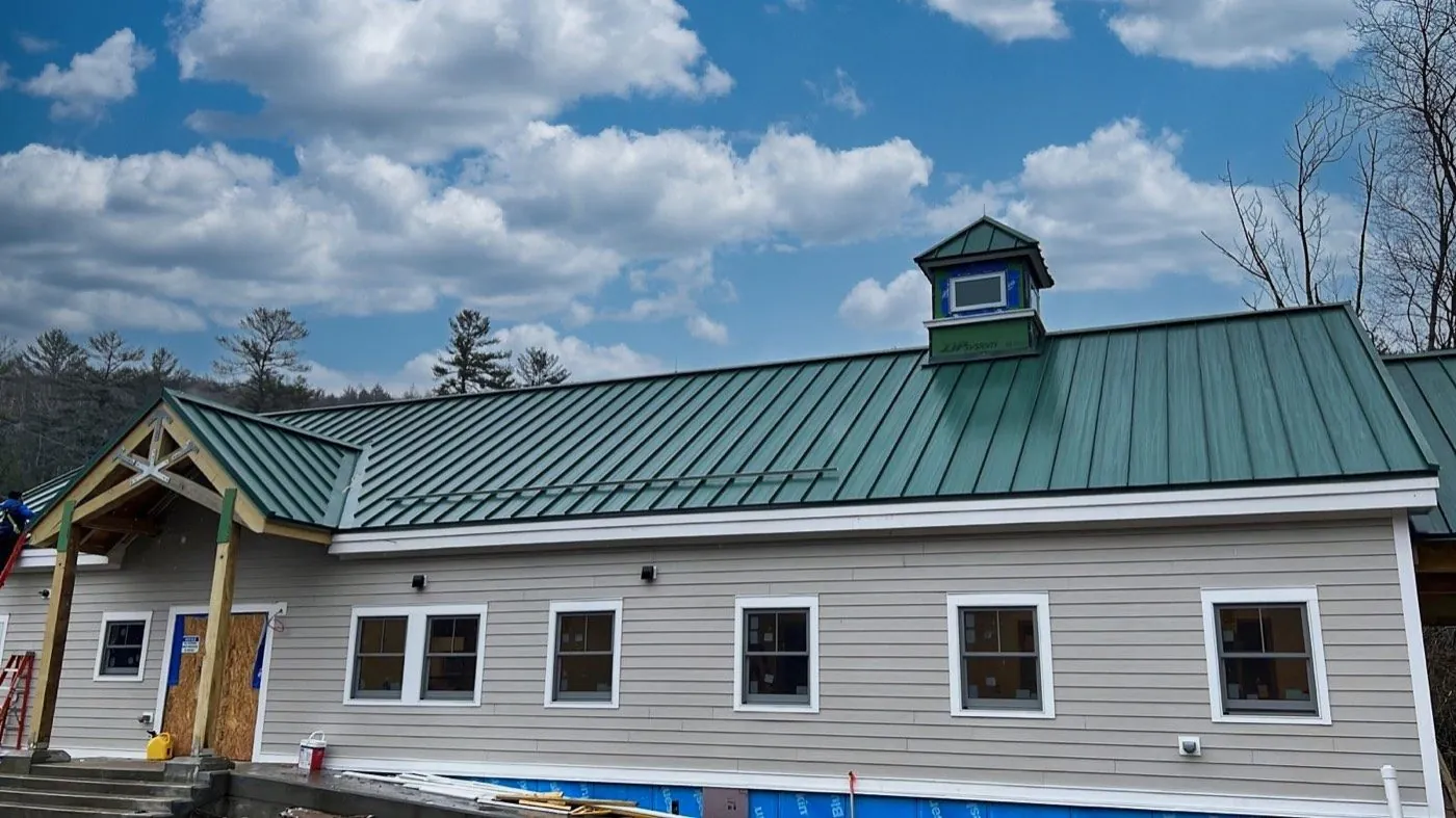 Long barn-style home with a green standing seam roof